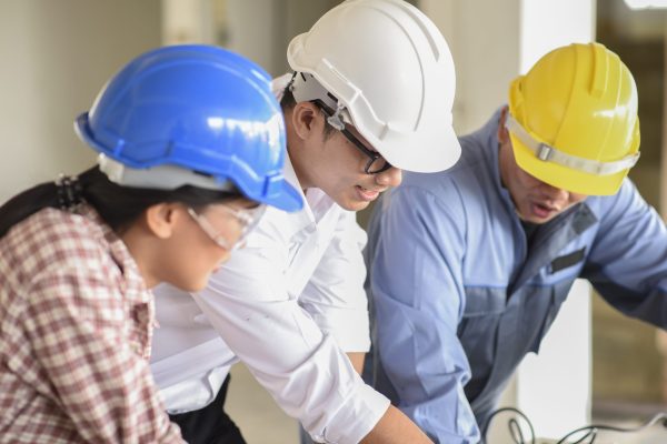 architects-discussing-plans-construction-site
