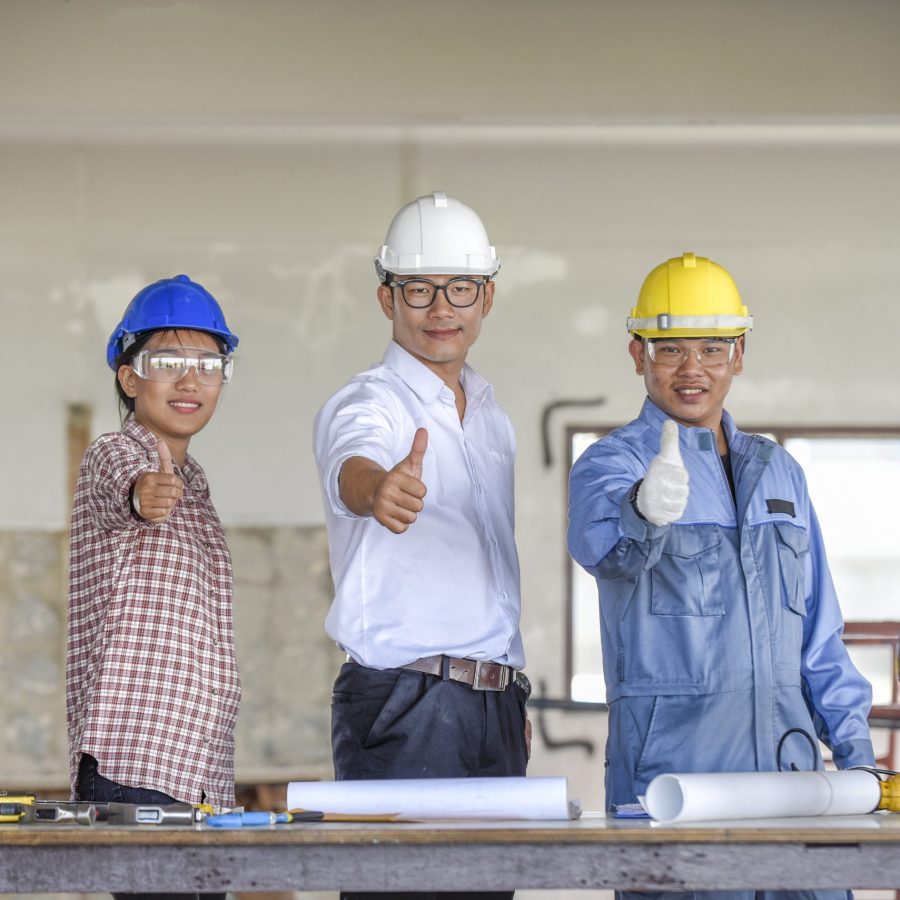 architects-gesturing-thumbs-up-while-standing-construction-site