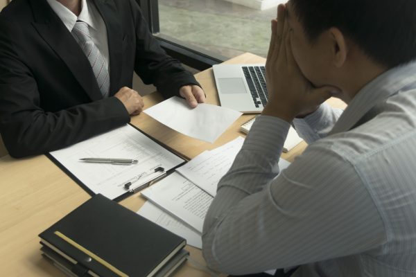 businessman-giving-envelope-colleague-desk-office