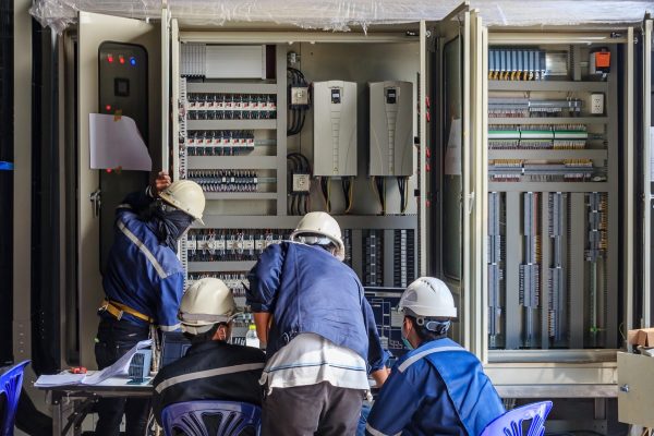Engineer working on checking and maintenance equipment at wiring on PLC cabinet, Engineer checking status step up transformer