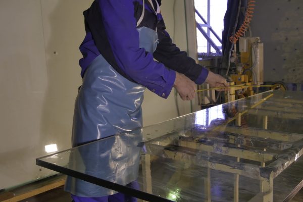 Cleaning and washing. Professional window washing equipment. Early spring windows cleaning. Maid cleans window. Male janitor using a sponge to clean a window in an office wearing an apron and gloves as he works