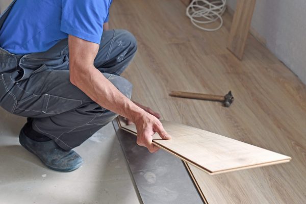 Worker lays laminate flooring in the apartment. The concept of working professions